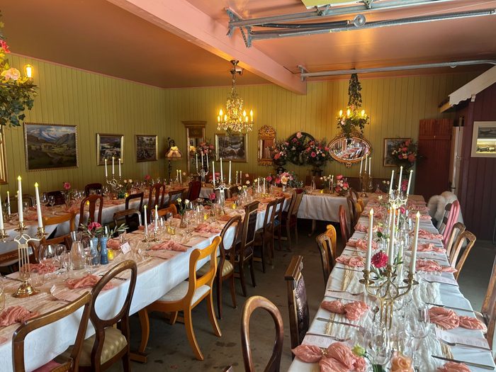 Dekket langbord med rosa lys og blomsterarrangementer i bankettsalen